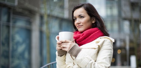 A woman sipping on a cup of coffee.
